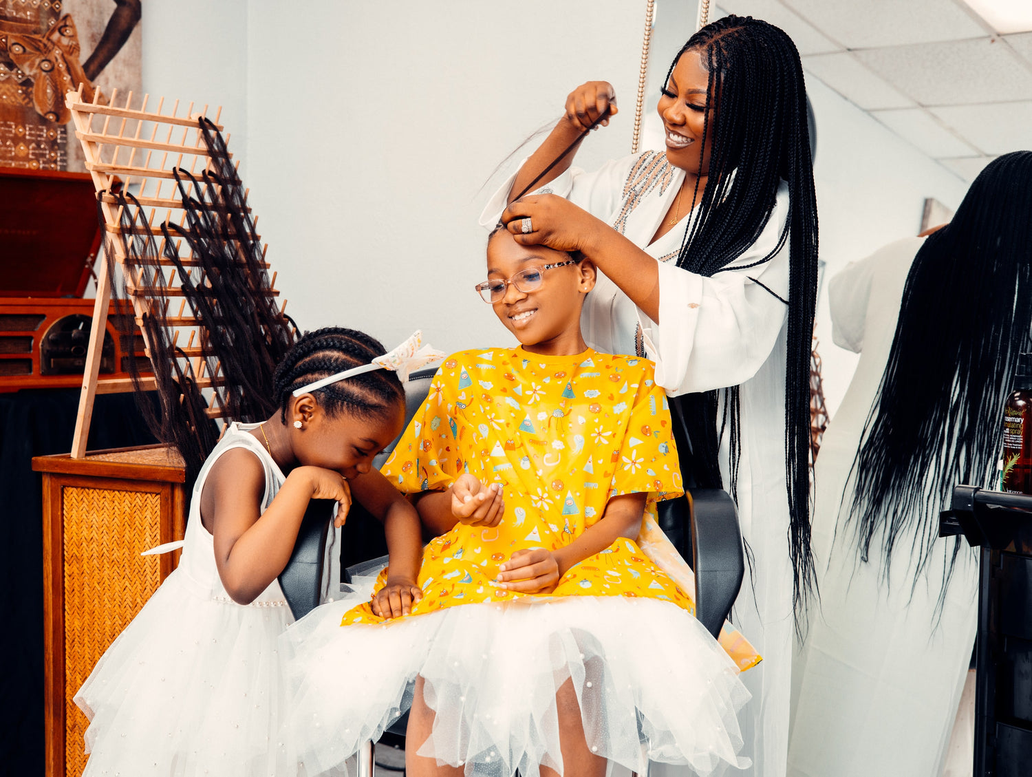 A girl getting hair done by her mom and all showing enthusiasm.